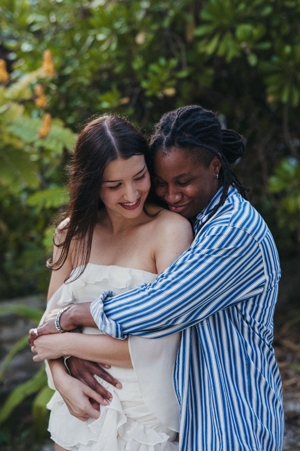 Intimate couple embracing on a lush tropical path with greenery and natural lighting in a classic sandy beach path in Holbox