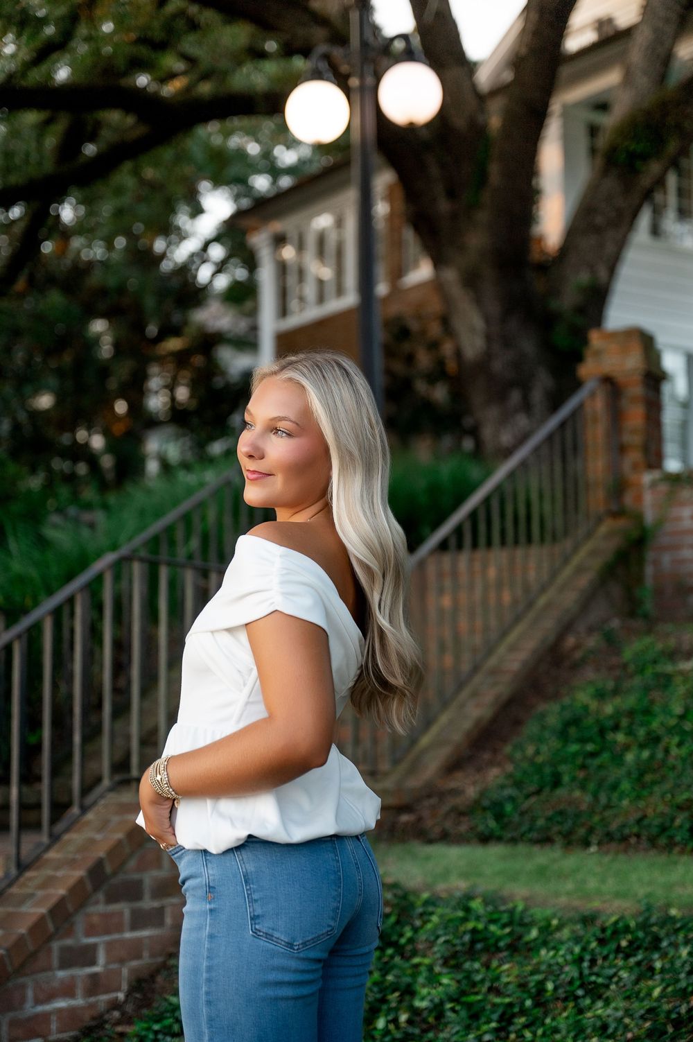 Summer fashion shoot on landscaped grounds with brick architecture.
