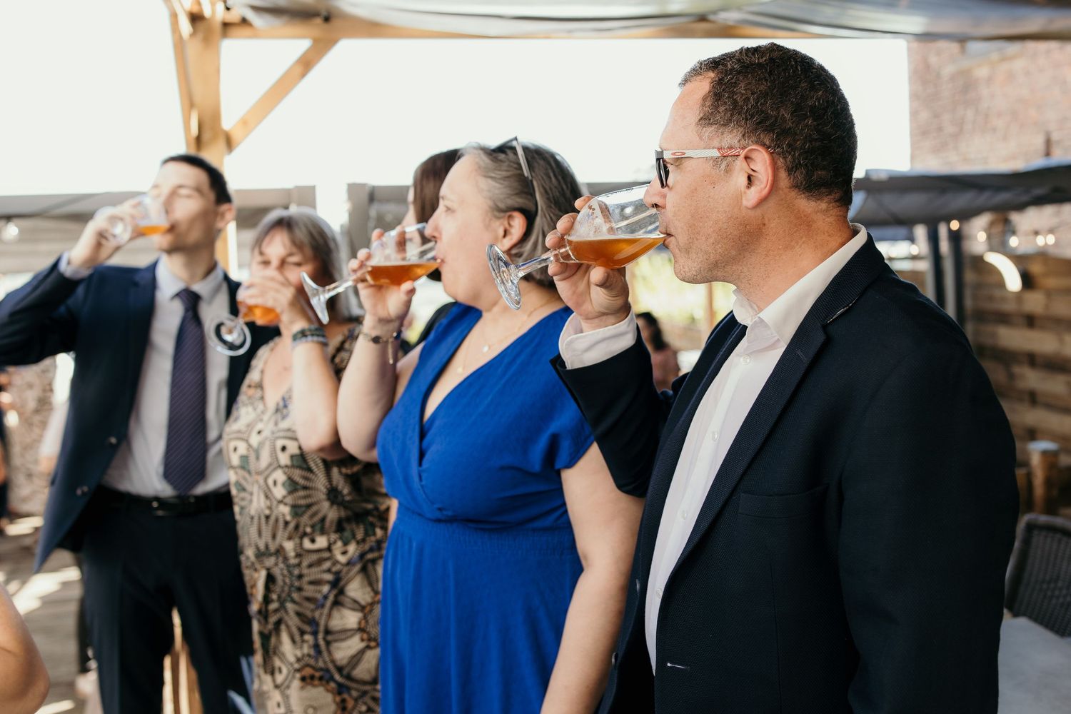 Wedding guests enjoying drinks and conversation at an elegant reception bar area.
