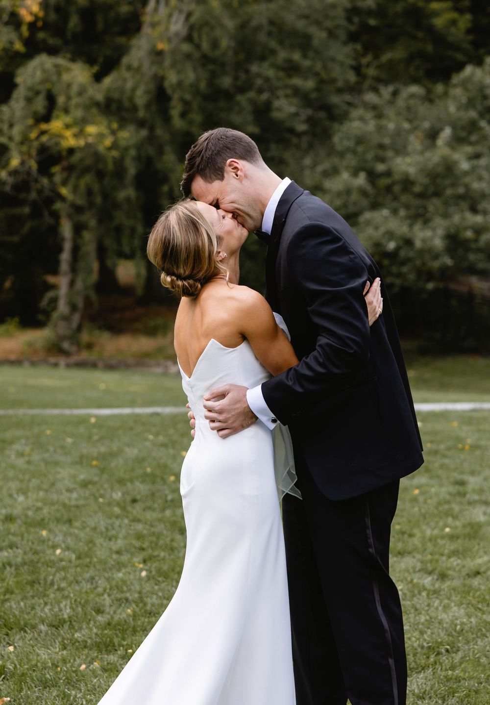 Romantic outdoor wedding photos showing tender moments between newlyweds on a grassy field. Appleford Estate. Villanova, PA.