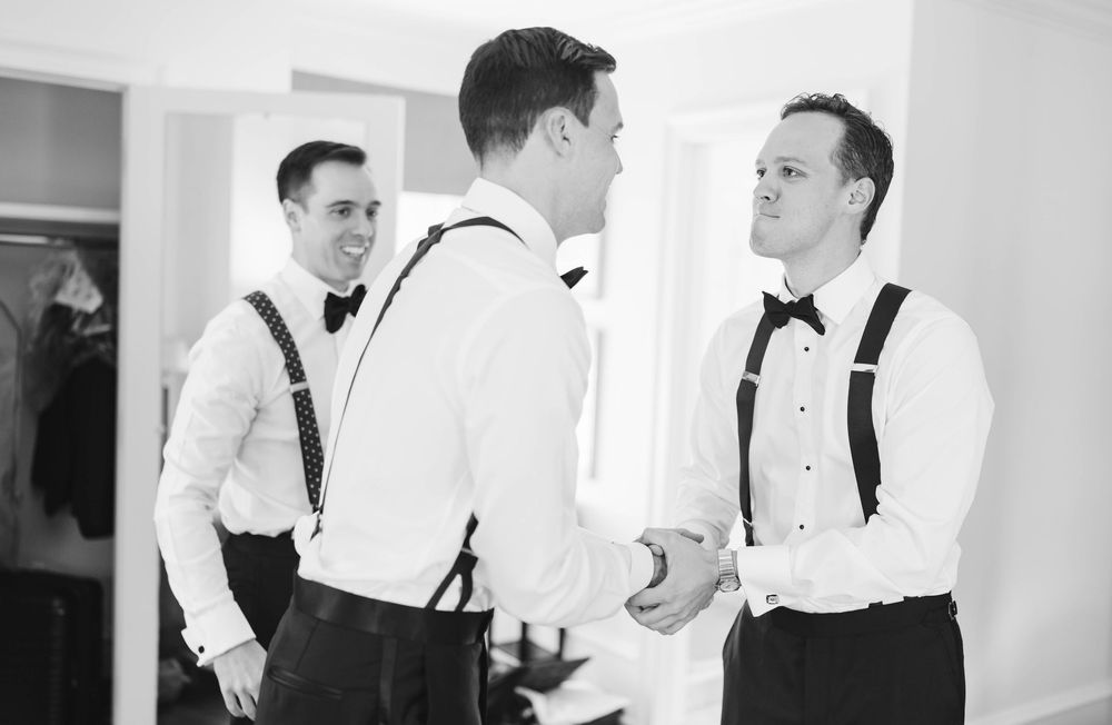 Groomsmen in classic black and white attire preparing for the wedding ceremony. Appleford Estate. Villanova, PA.