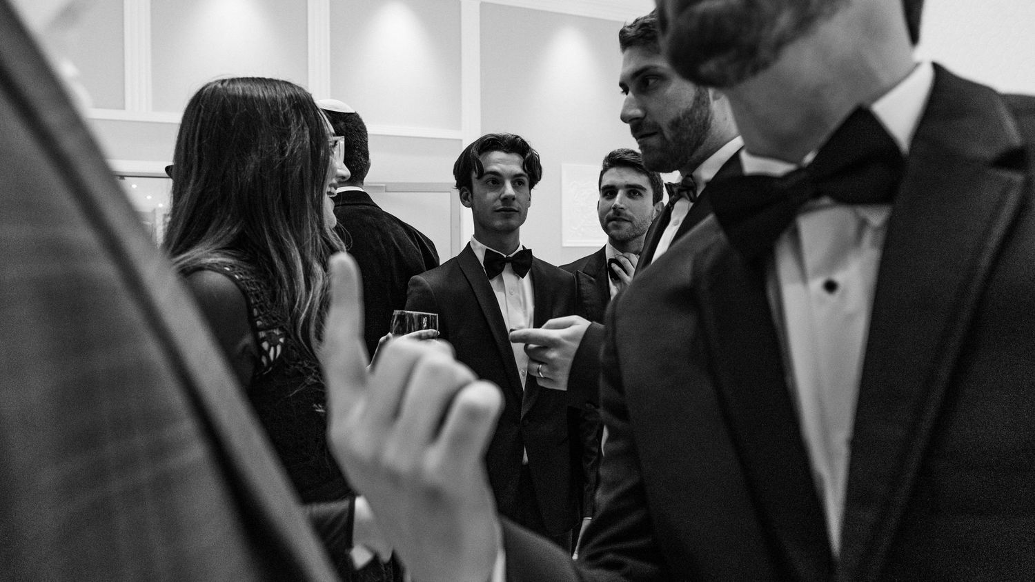 Black and white photo showing a group of people in formal attire at an elegant event or gathering.