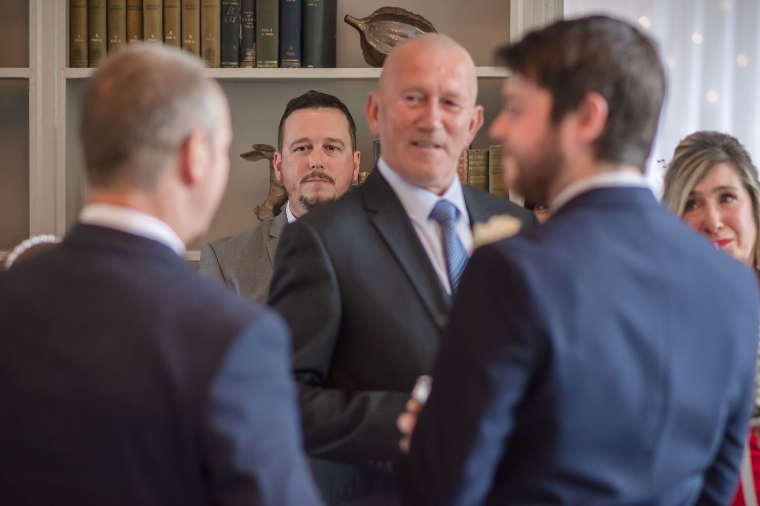 People in business attire gather in conversation at a formal indoor event.