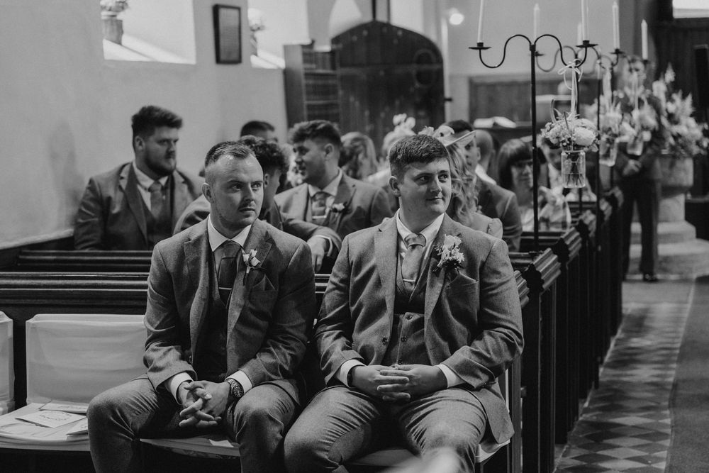 A groom awaiting his bride at the onsite church at Birtsmorton Court, Worcestershire
