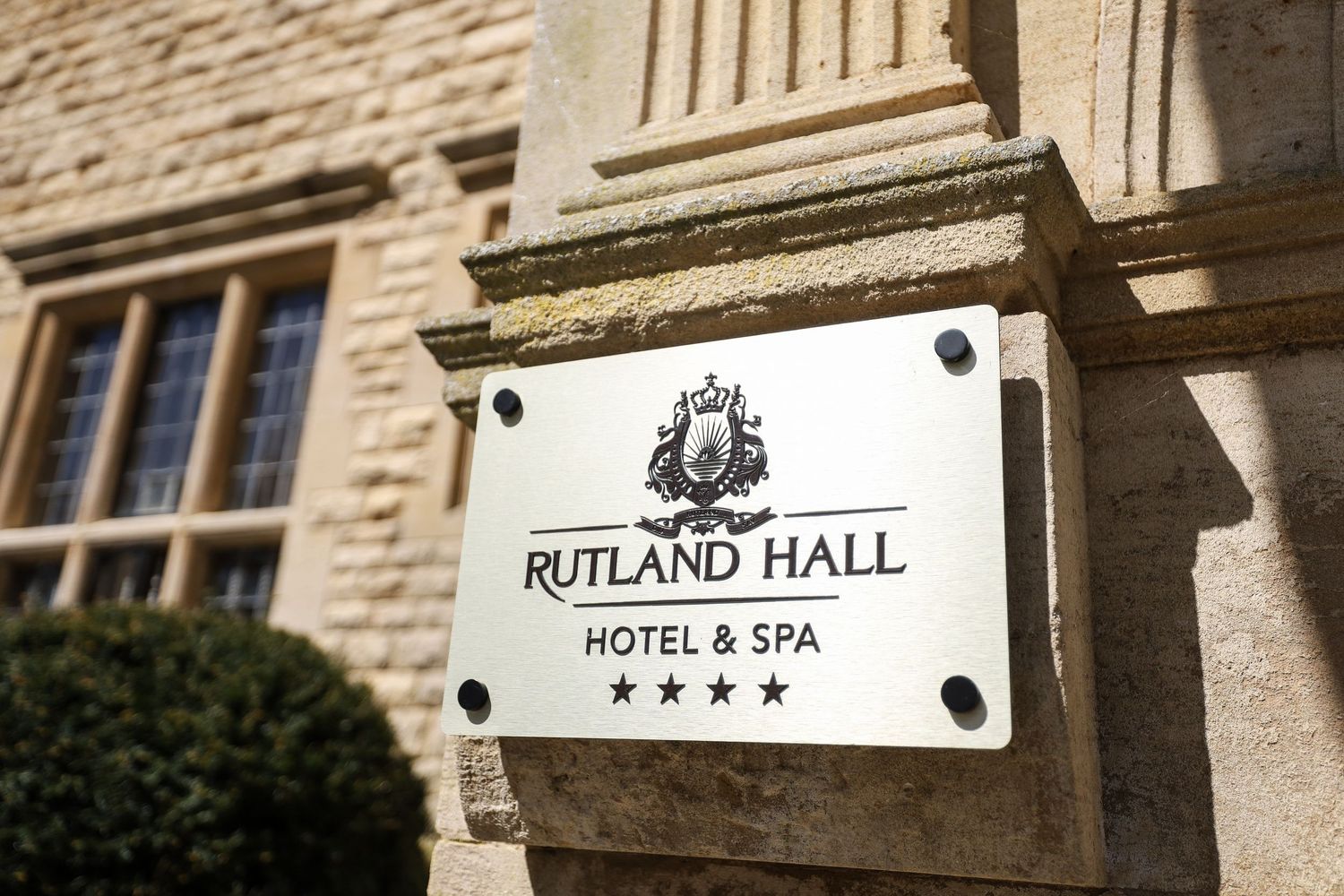 A close-up view of an elegant white sign for Rutland Hall Hotel & Spa mounted on a stone building exterior.
