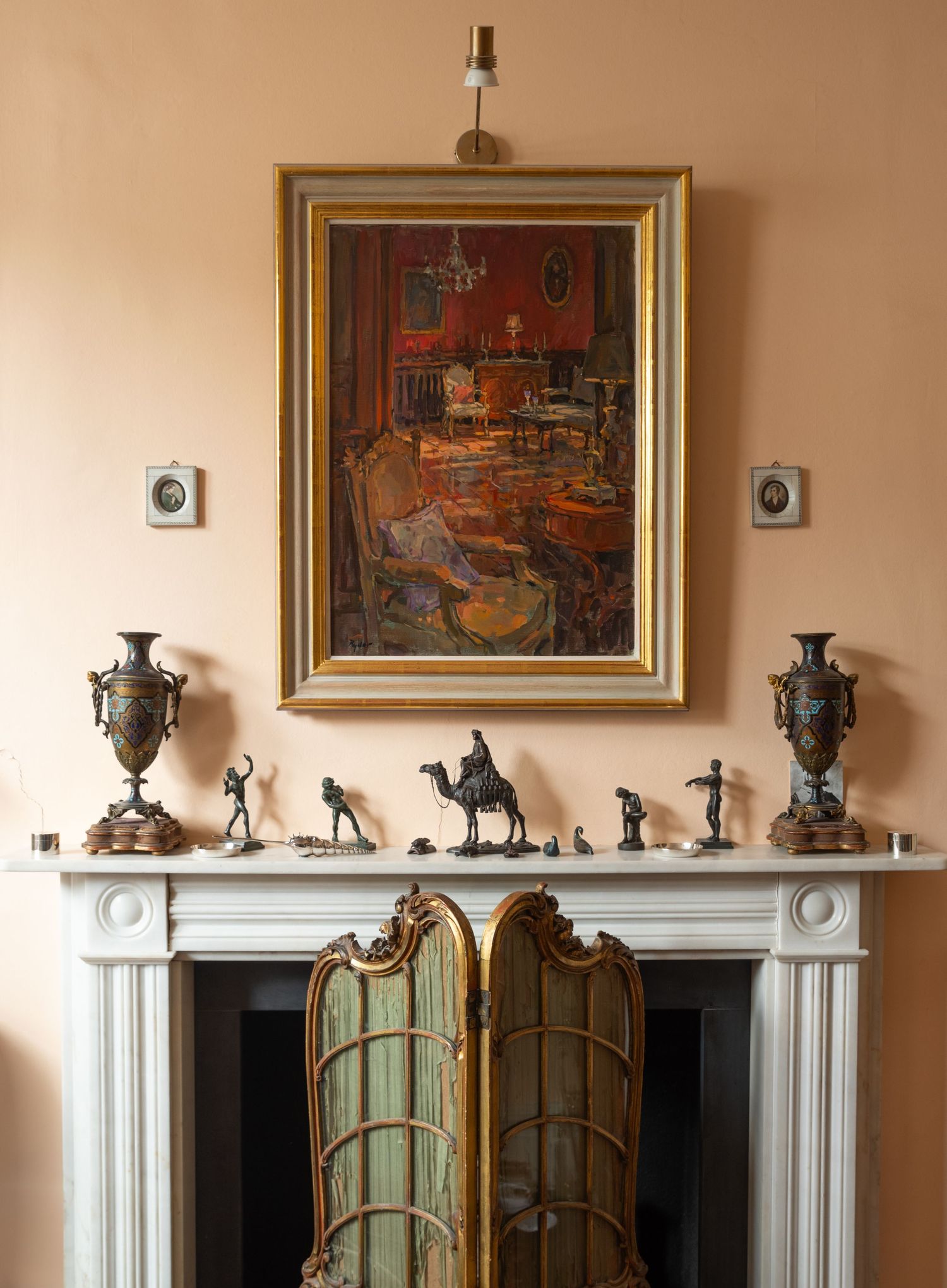 Elegant living room with white mantelpiece displaying decorative sculptures and framed artwork.