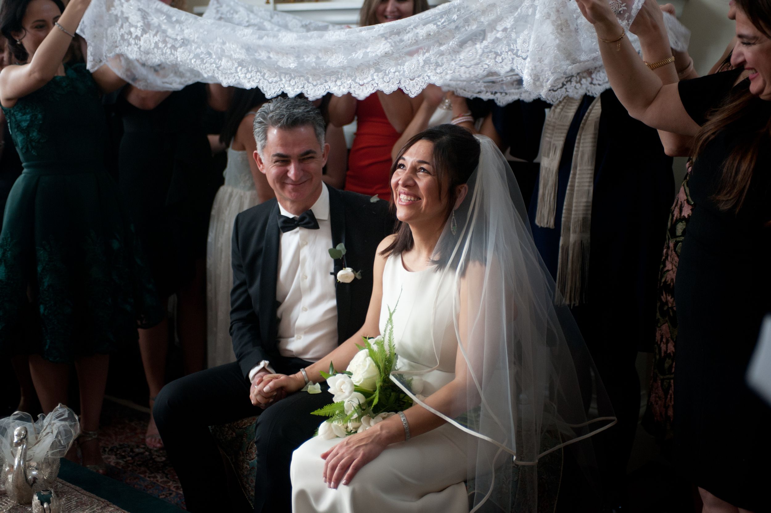 A couple shares a tender moment during their wedding ceremony in a dimly lit church setting.