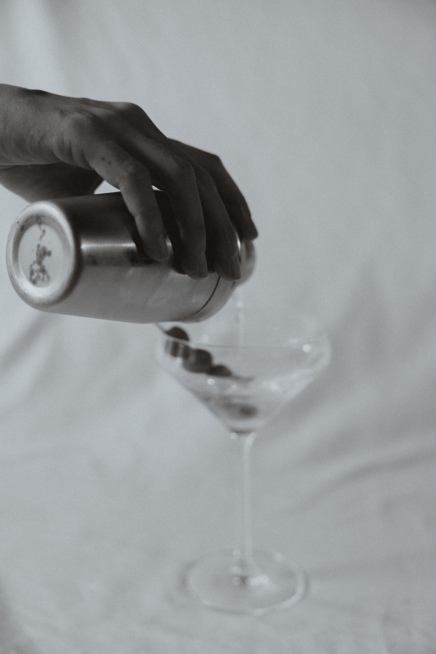 A sequence of black and white photos showing champagne being poured into a glass, creating a bubbly cascade effect.