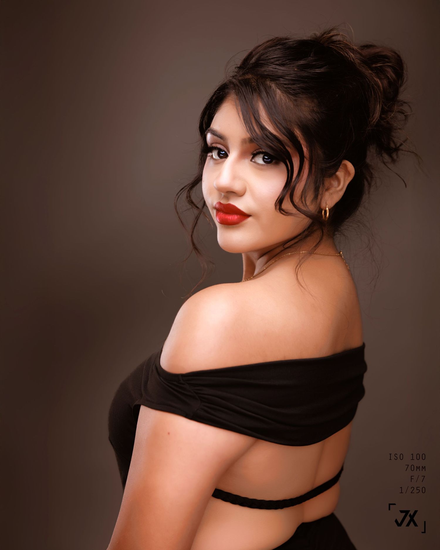 A sensual boudoir portrait series featuring dramatic lighting and a black fabric against a dark background.