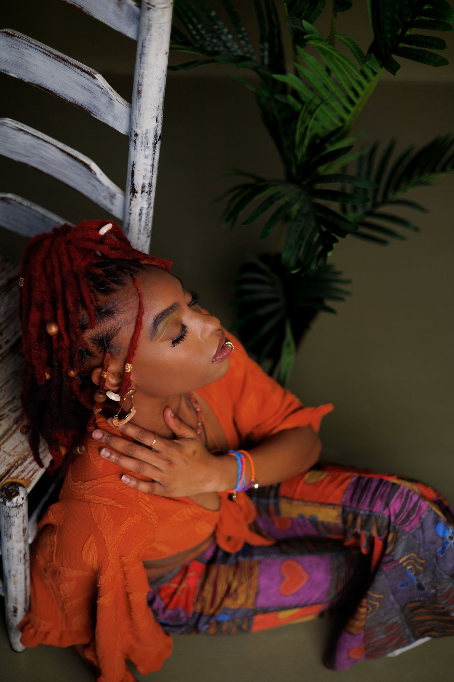 Person in bright orange top with red hair lying back and laughing expressively in sequence of connected photos.