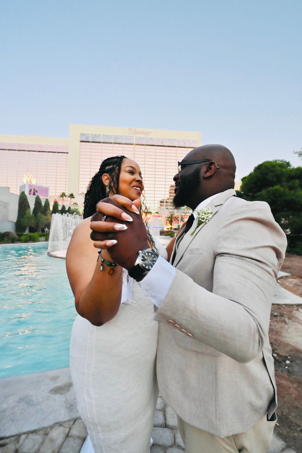 Bride and groom sharing a tender moment by a Las Vegas resort pool during their wedding day.