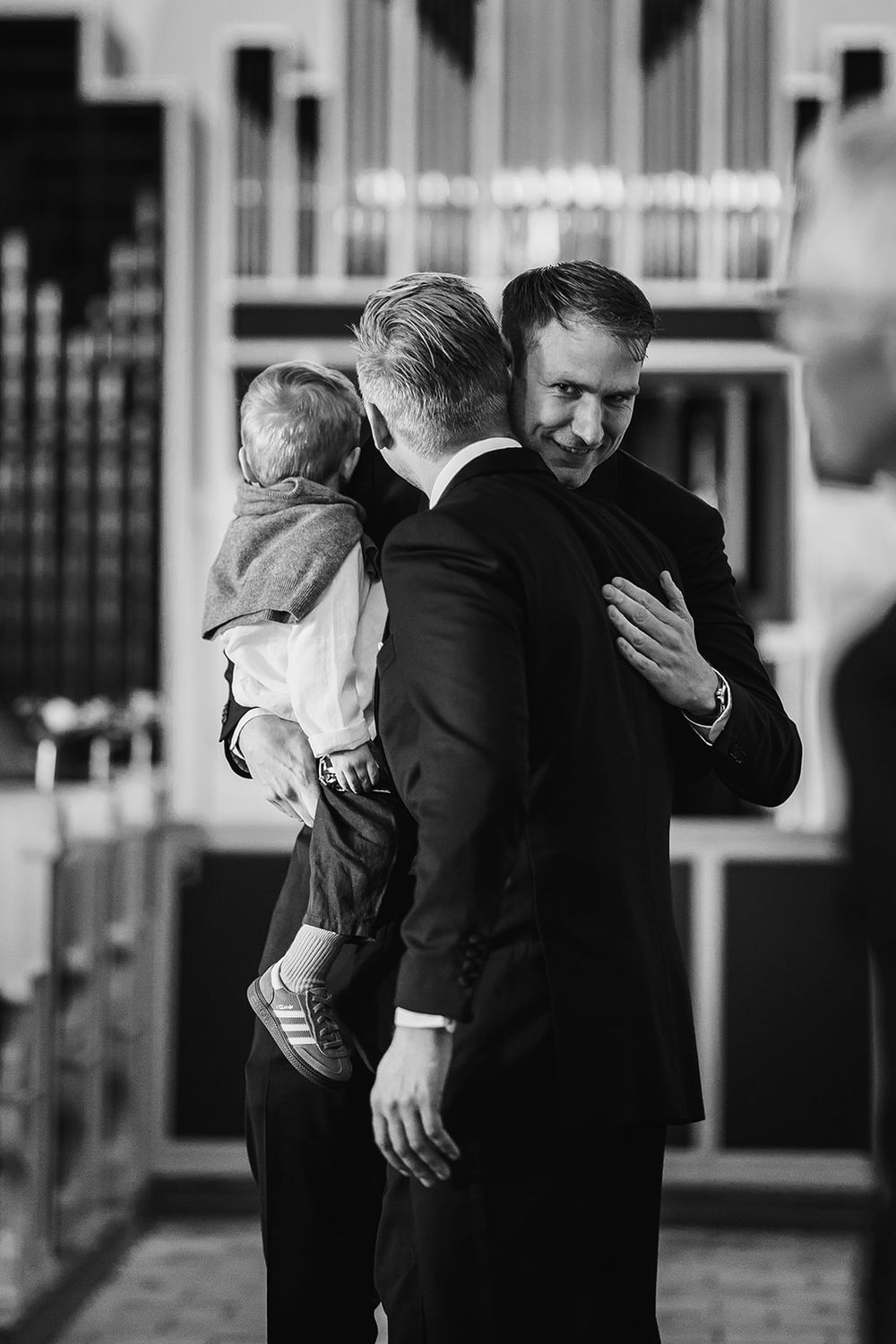 A series of black and white photos showing emotional embraces between people in formal attire at an event.