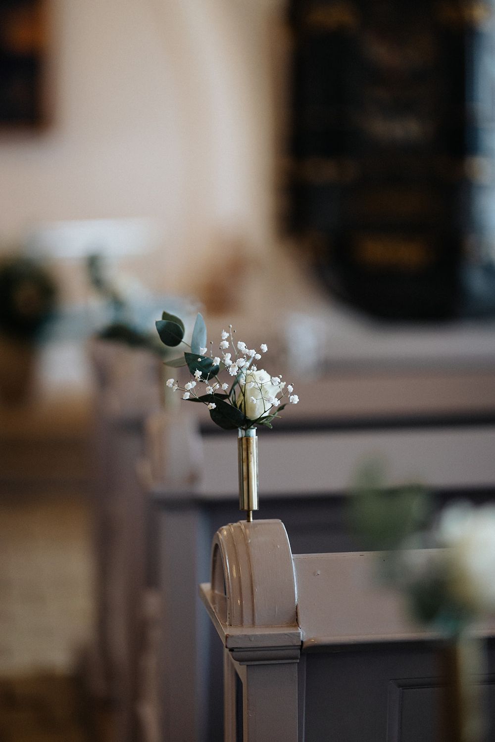 A vintage-style gramophone speaker horn mounted on a dark stand against a blurred background.