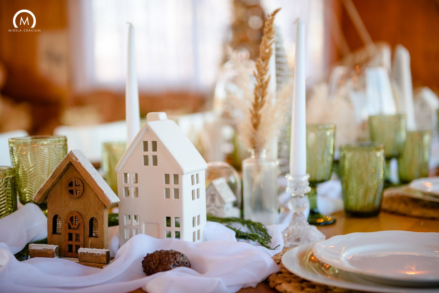 A collection of miniature white ceramic houses and decorative items arranged in a soft-focus display.