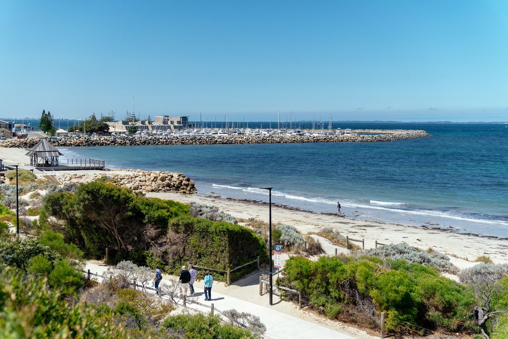 Panoramic view of a beautiful beach coastline with white sand and blue waters.