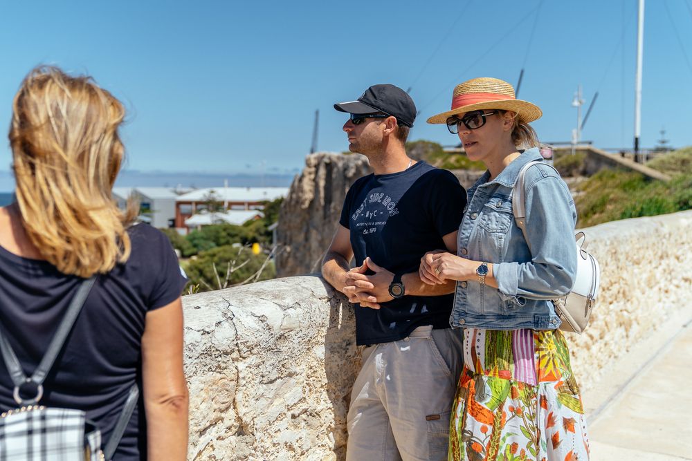 People enjoying a sunny day at a coastal overlook with ocean views.