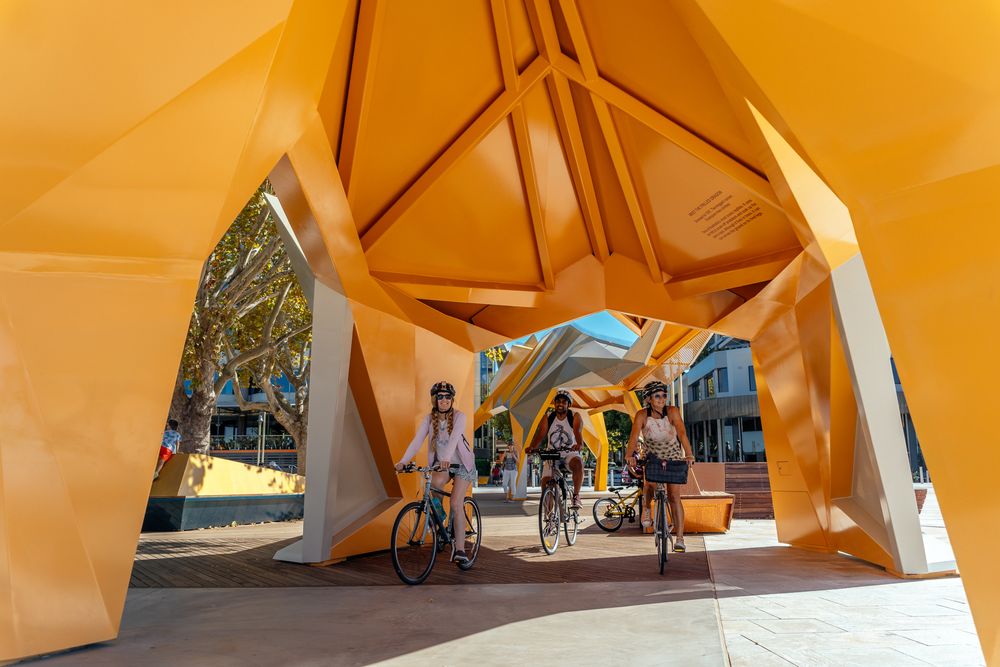Modern orange architectural structure with geometric angles creating unique shadows and patterns.