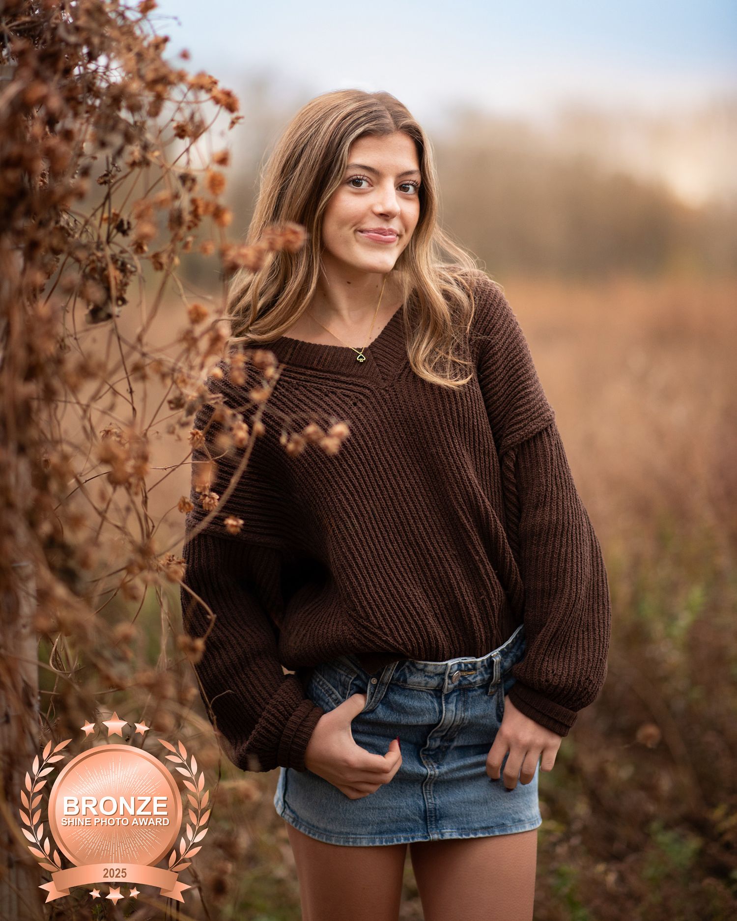 Teen girl in brown sweater and denim skirt posing in autumn field, Bronze Award winning photo.Middletown NJ