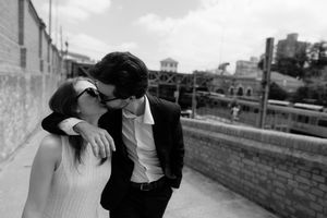 A romantic black and white moment captured on an urban rooftop with city buildings in the background.