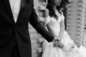 Romantic black and white wedding photography collage showing intimate moments between bride and groom against brick wall.