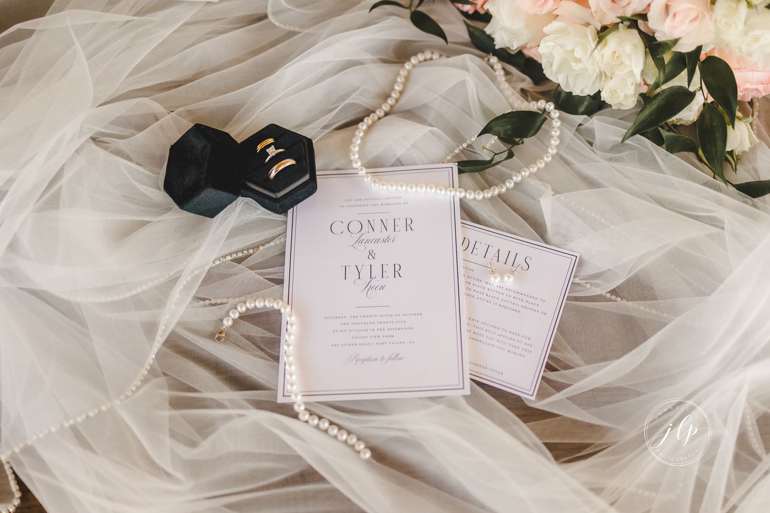 Elegant wedding stationery displayed with soft pink florals and pearl accessories.