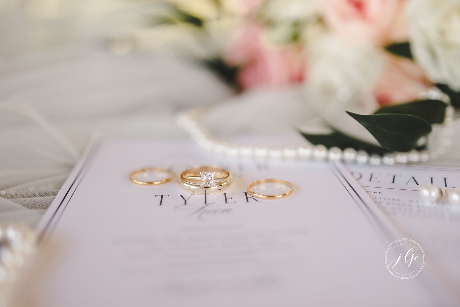 Elegant wedding invitation details with delicate floral arrangements and gold accents on white paper.