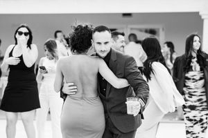 Black and white dance sequence showing couples in elegant formal attire during a celebration.
