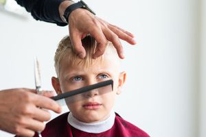Close-up of hands styling hair with professional grooming tools.