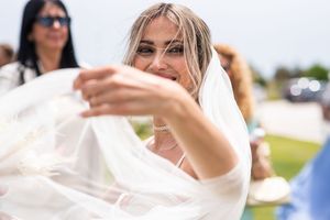 Candid outdoor wedding photography showing guests and celebrations in bright sunlight.