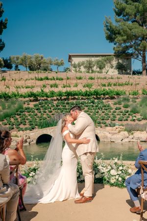 Wedding ceremony taking place in a beautiful garden setting with terraced landscaping.
