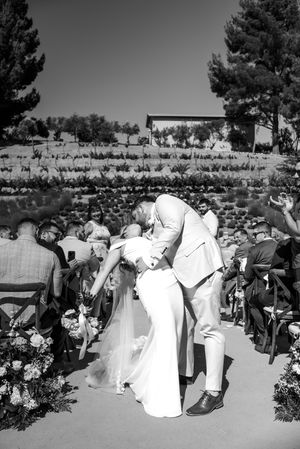 Black and white photo of wedding guests celebrating during an outdoor ceremony.