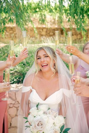 Wedding celebration with champagne toasts and joyful moments under garden greenery.