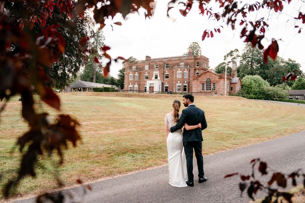 First look in British wedding outfits — bride in Pronovias gown, groom in tuxedo, fusion wedding photography