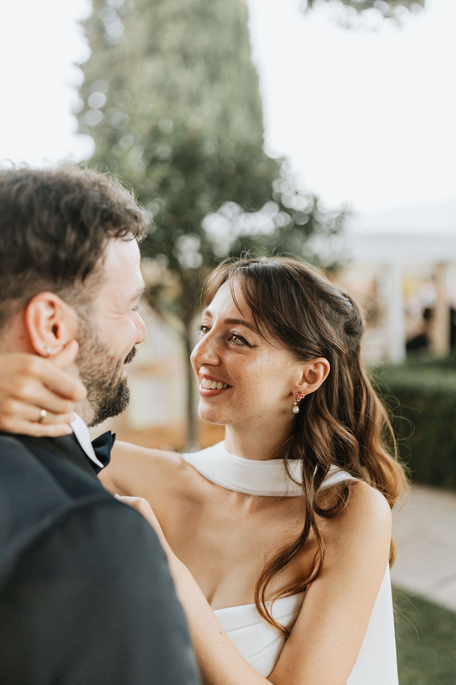 A romantic moment between a couple on their wedding day, with soft natural lighting and greenery in the background. Italy Wedding
