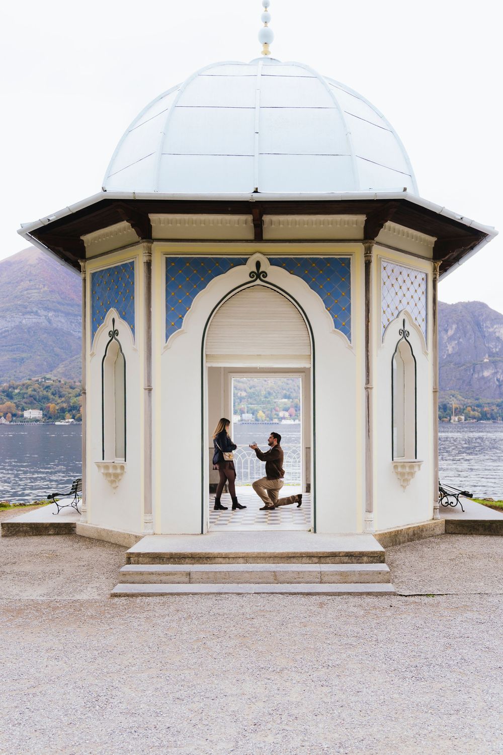 A romantic proposal sequence showing silhouettes in an elegant white gazebo overlooking a lake and mountains.