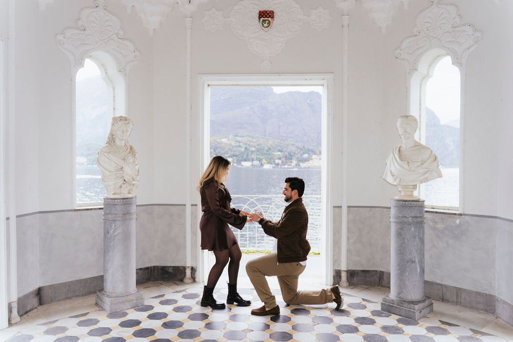 A panoramic view of people walking through a white arched colonnade hallway with repeating architectural elements.