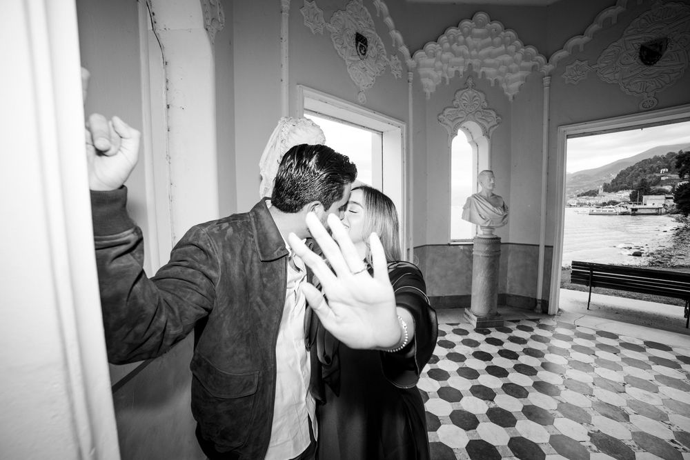 A romantic black and white moment captured in an ornate room with a checkered floor and architectural details.