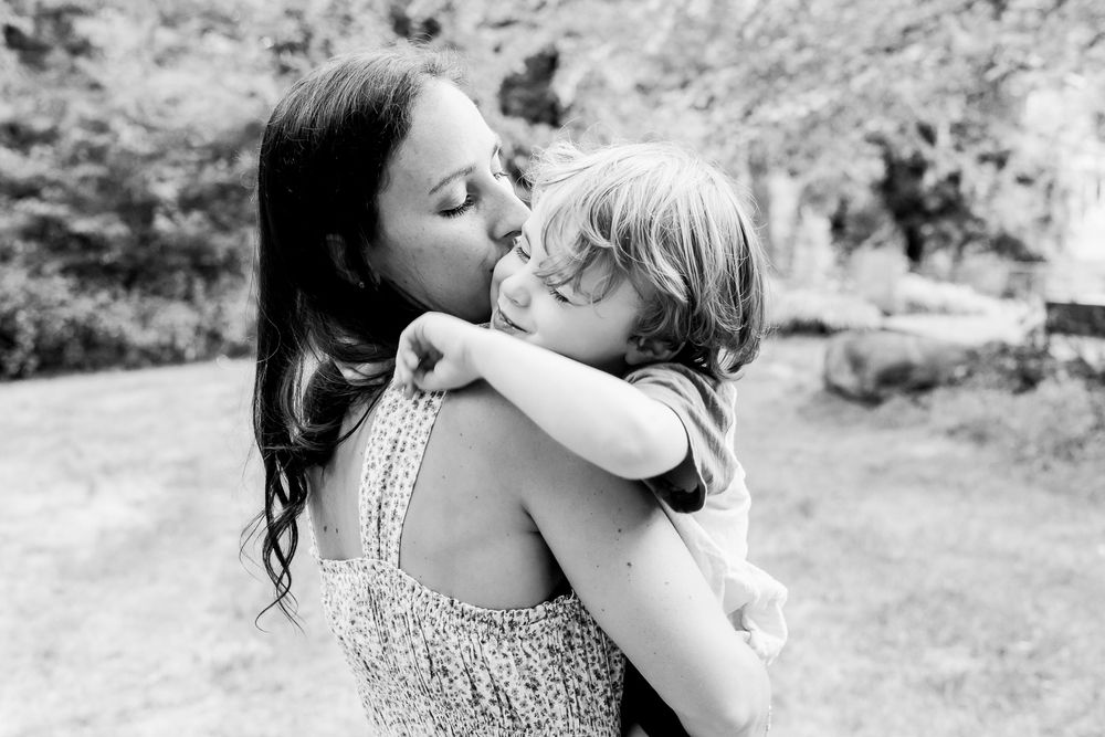 Candid family photography capturing a playful moment between a father and baby during an on-location session in Andover, MA.
