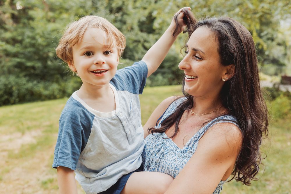 Outdoor family lifestyle photography capturing a joyful moment between a mother and child in natural light in Andover, MA.