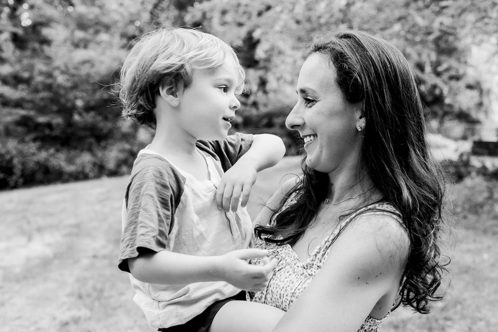 Candid family photography of a mother and son sharing a natural, emotional moment during an outdoor session in Boston, MA.