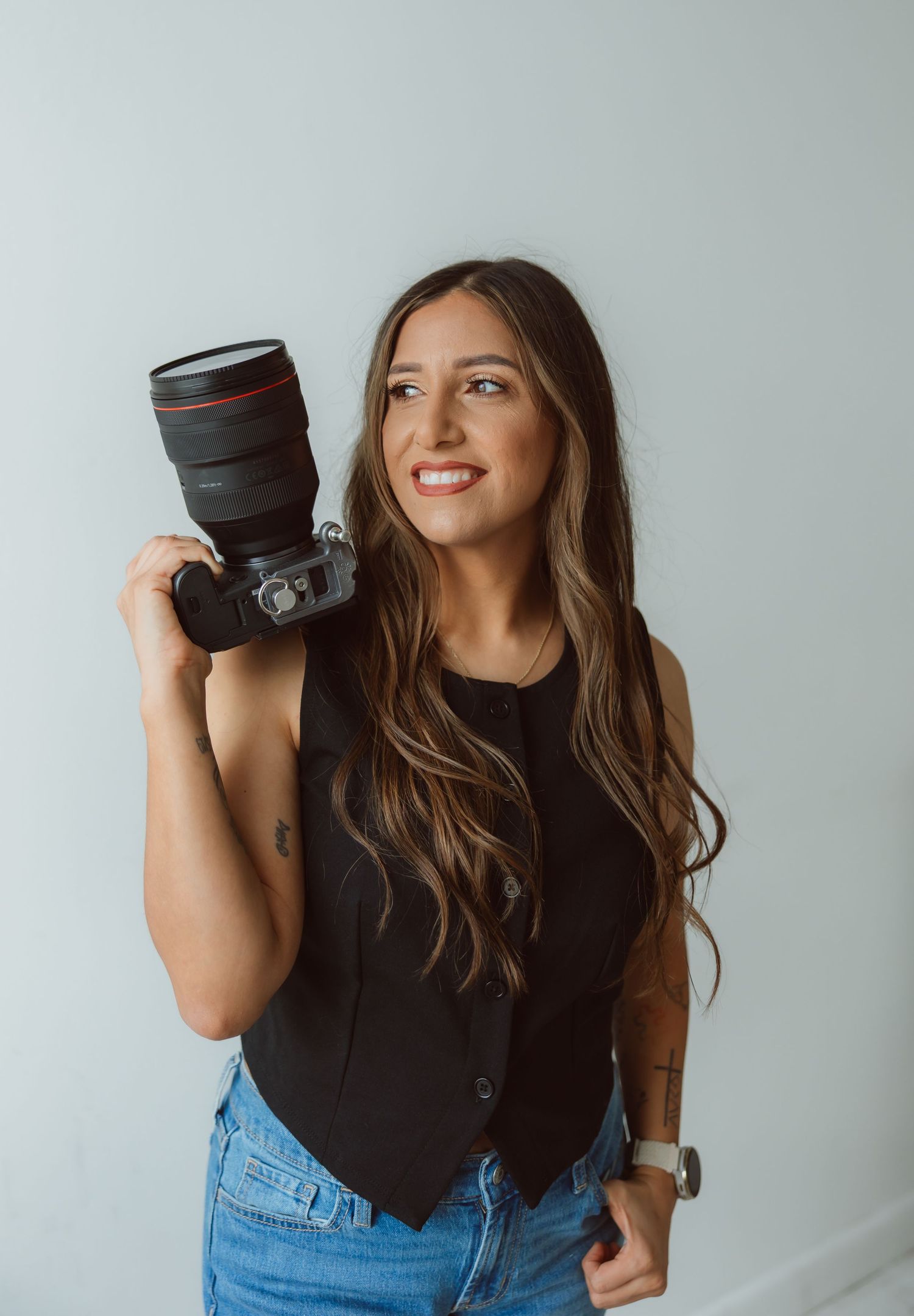 Branding portrait of a photographer holding a camera during a personal branding session.