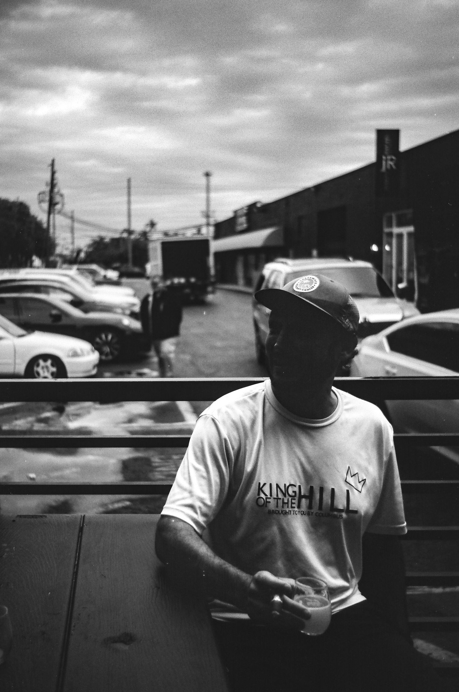 A person in a King branded t-shirt standing in a parking lot on an overcast day.