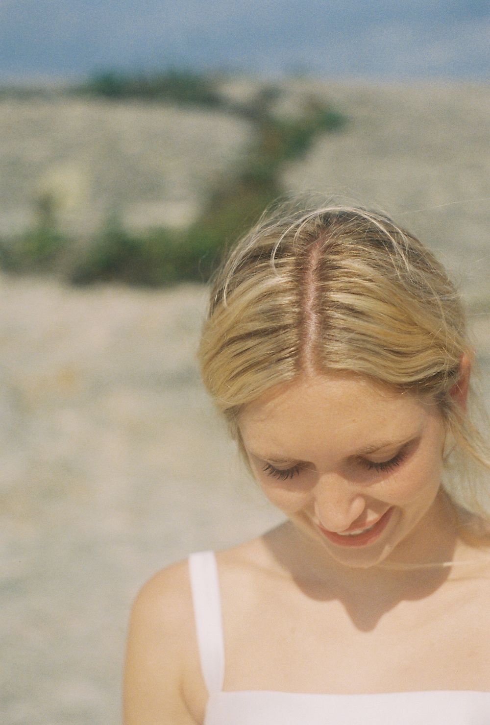 Close-up portrait showing elegant bridal hairstyle and dress details.