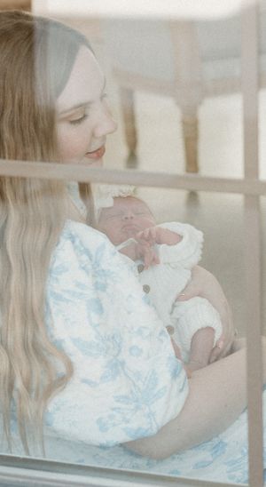 Soft ethereal image through window showing figure in light blue floral dress.