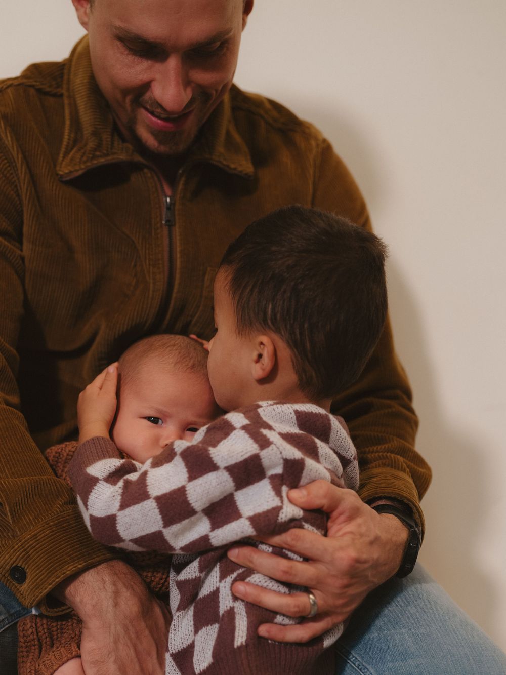 An intimate family moment captured in warm tones during a studio photo session.