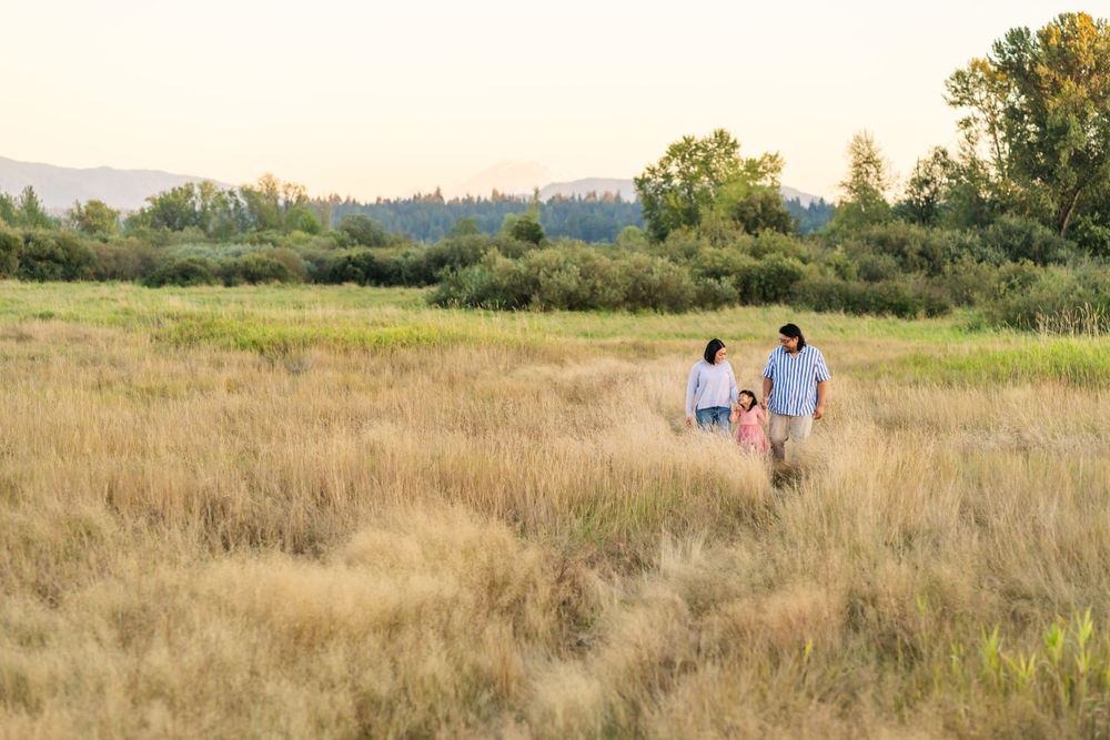 Parents walking with daughter in a field in Redmond.