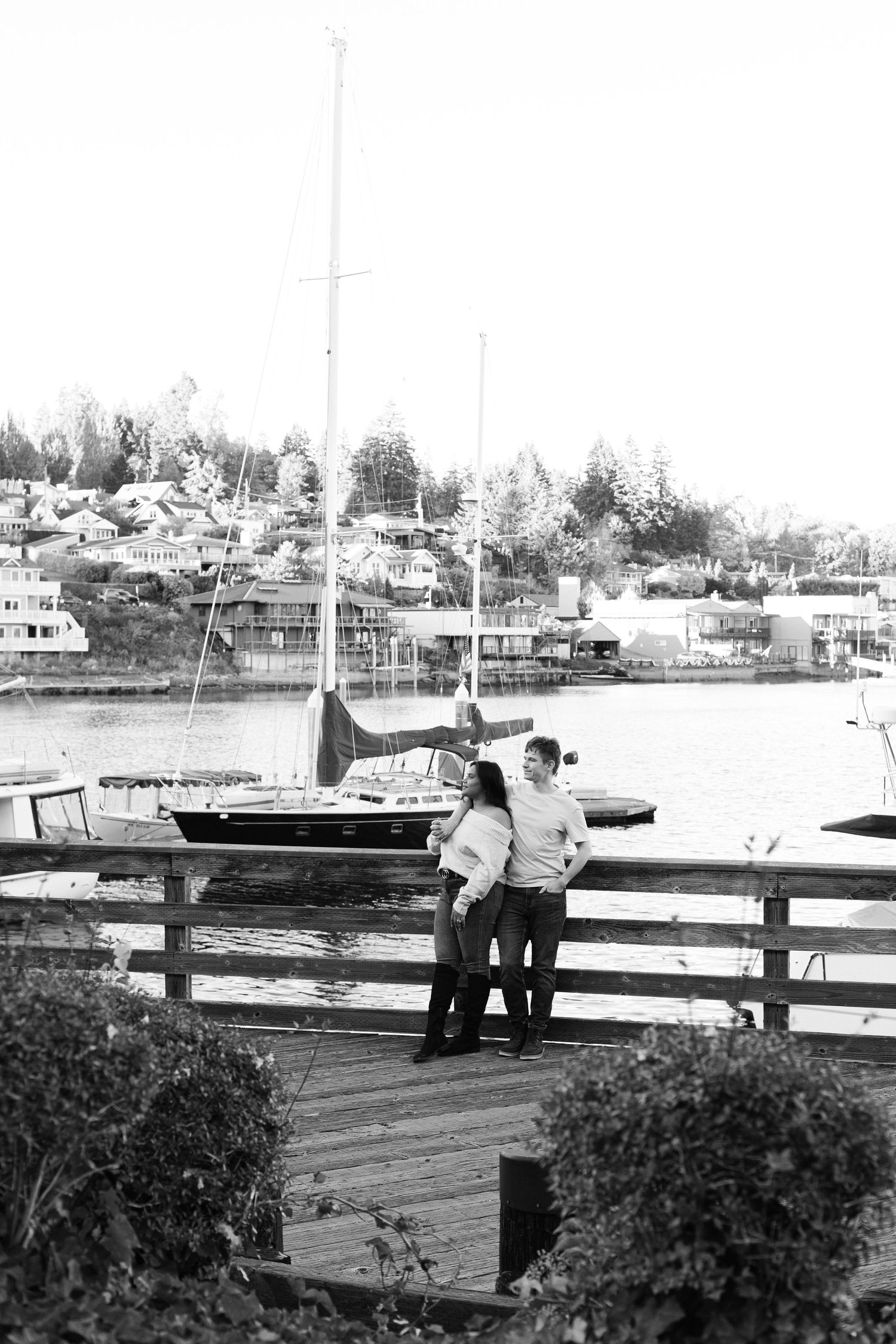 A sequence of black and white photos showing people standing at a dock overlooking boats and waterfront homes.