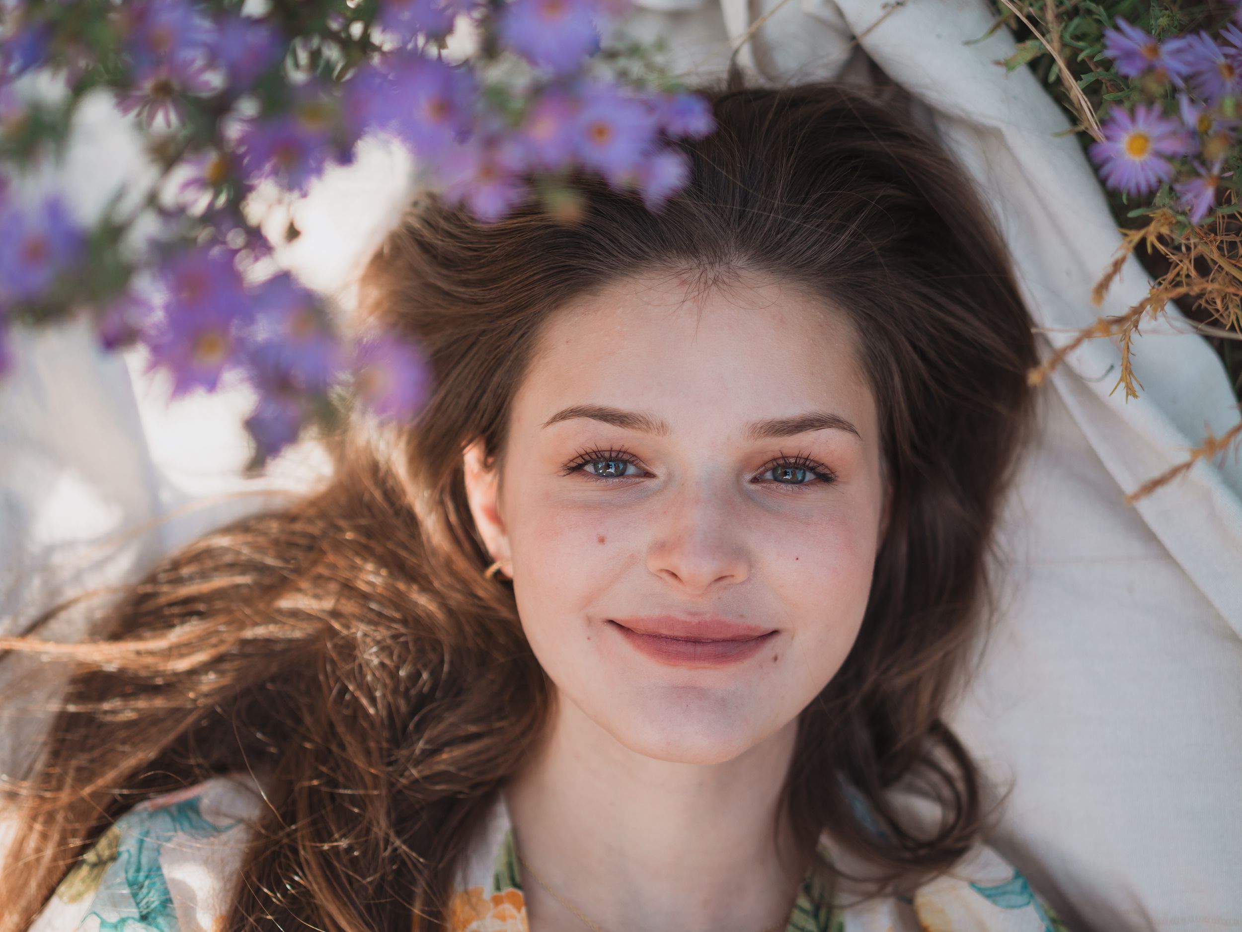 A series of springtime portraits featuring purple wisteria flowers framing the composition against a bright background.