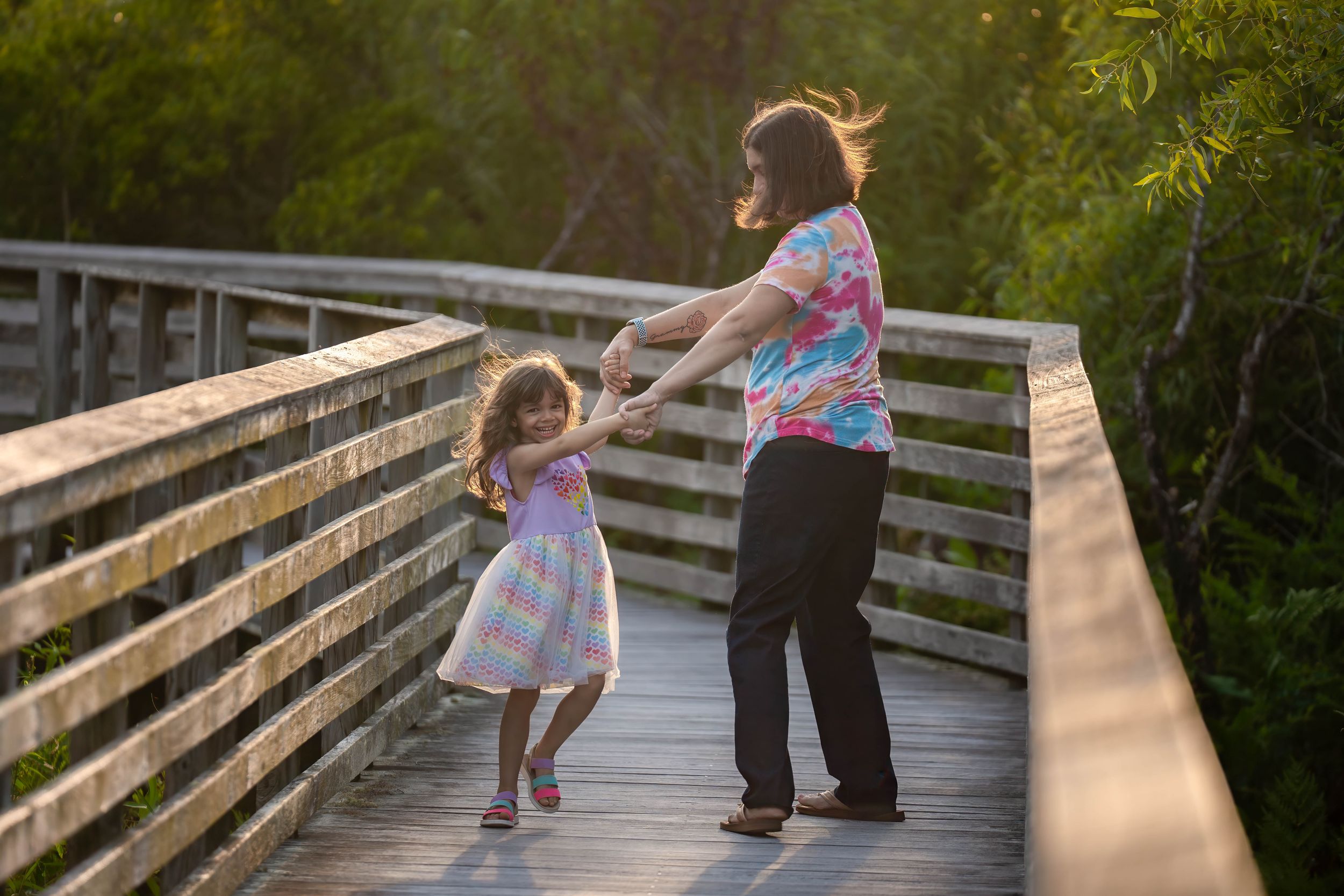 Toni and evelyn playing on the boardwalk of juno dunes natural area during a family session in juno beach florida