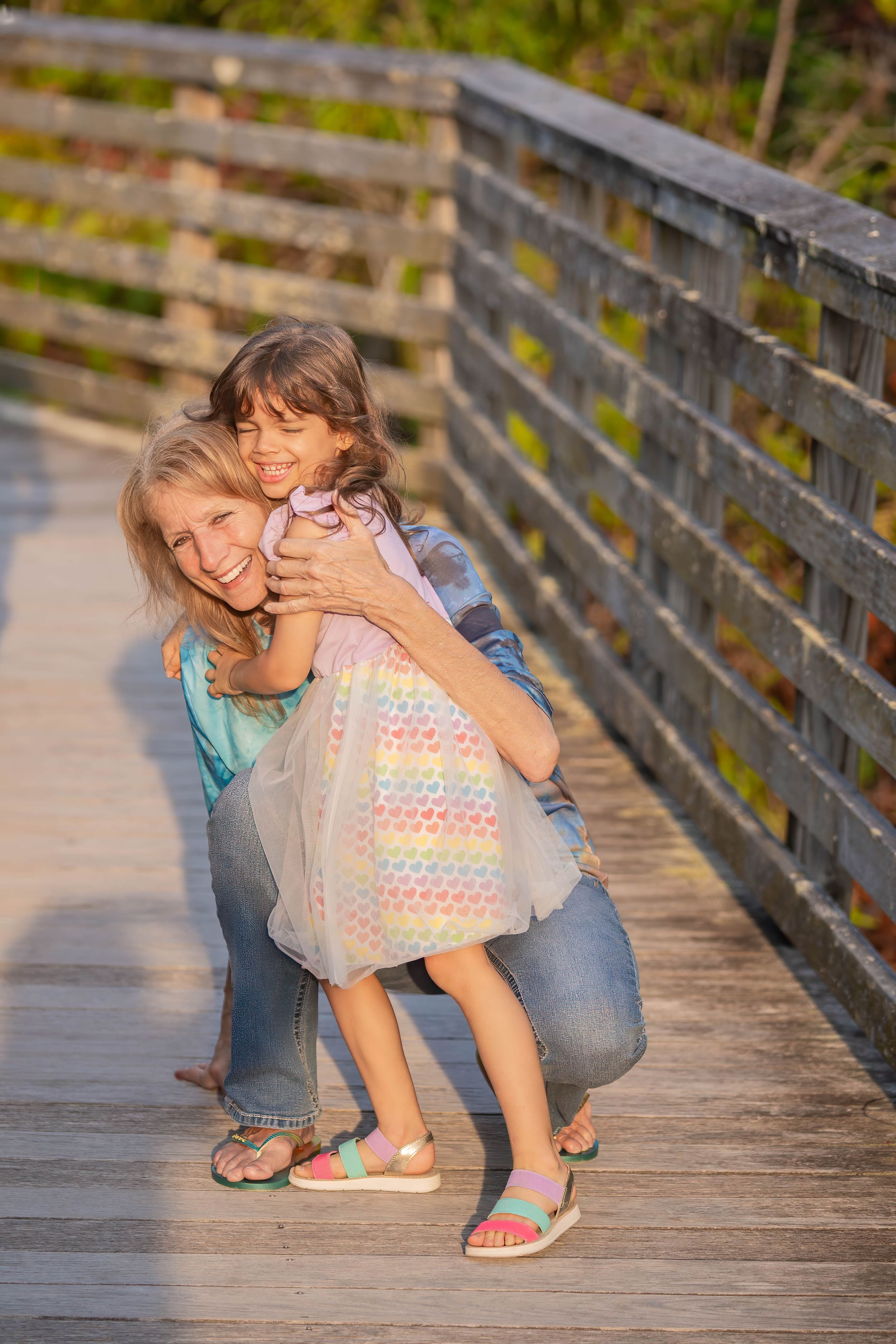Gina and evelyn playing on the boardwalk of juno dunes natural area during a family session in juno beach florida